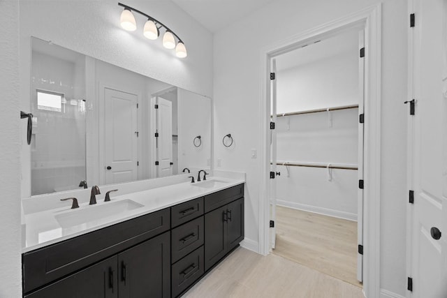 bathroom featuring hardwood / wood-style floors, vanity, and walk in shower