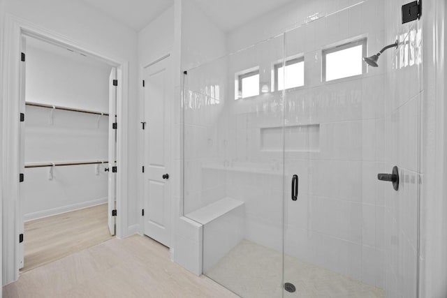 bathroom featuring a shower with shower door and wood-type flooring