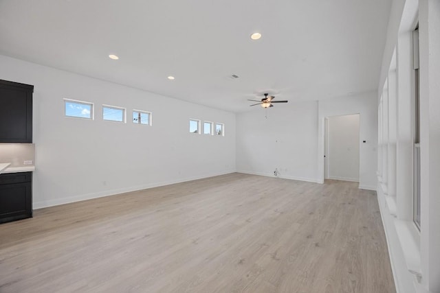 unfurnished living room featuring light wood-type flooring and ceiling fan