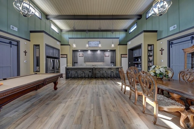 recreation room featuring beamed ceiling, a towering ceiling, light hardwood / wood-style floors, and plenty of natural light