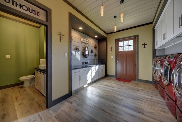 clothes washing area with wood ceiling, ornamental molding, light hardwood / wood-style floors, and independent washer and dryer