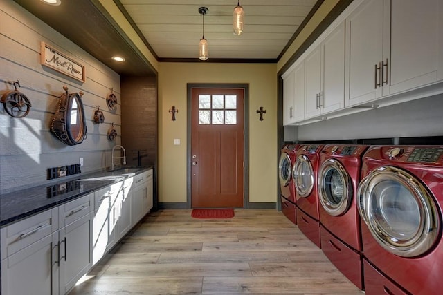 clothes washing area featuring light wood-type flooring, ornamental molding, sink, washer and dryer, and wooden ceiling