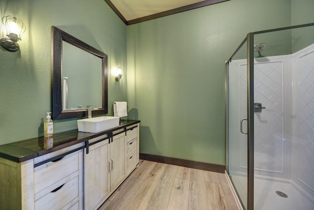 bathroom featuring hardwood / wood-style flooring, vanity, crown molding, and walk in shower