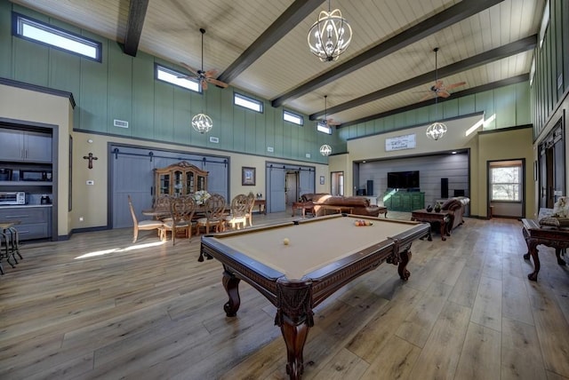 playroom featuring light wood-type flooring, a towering ceiling, and ceiling fan