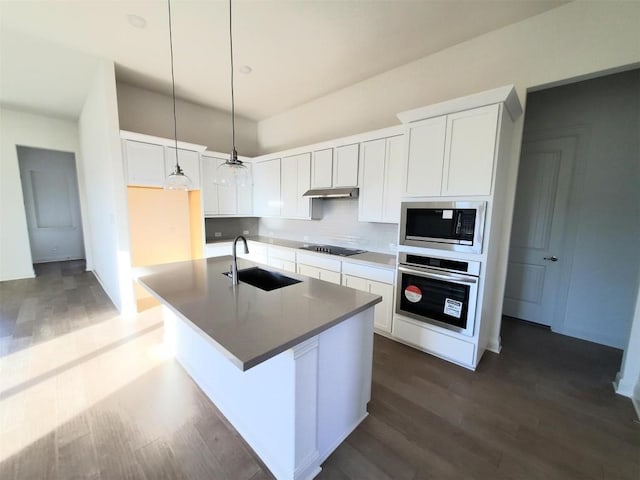 kitchen with a kitchen island with sink, decorative light fixtures, sink, appliances with stainless steel finishes, and white cabinets