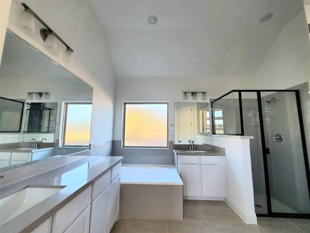 bathroom with tile patterned floors, separate shower and tub, vaulted ceiling, and vanity