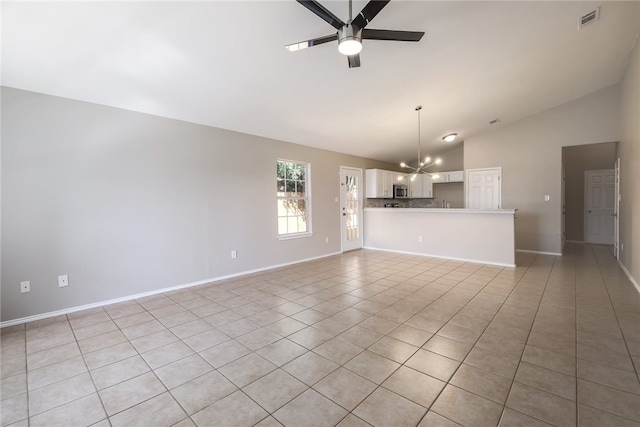 unfurnished living room featuring light tile patterned floors, ceiling fan with notable chandelier, and lofted ceiling