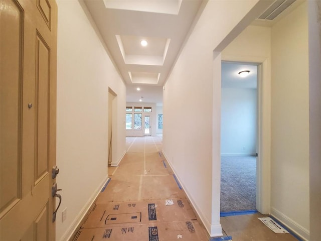 hall with light tile patterned flooring, french doors, and a tray ceiling