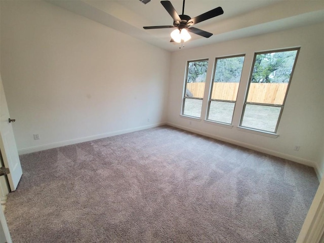 spare room featuring carpet floors, ceiling fan, and baseboards