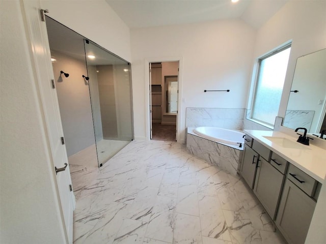 bathroom with lofted ceiling, a garden tub, vanity, marble finish floor, and walk in shower