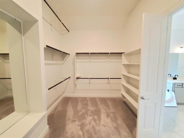 spacious closet with attic access, light carpet, and a sink