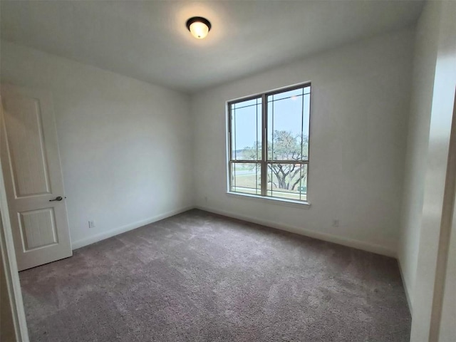 carpeted spare room featuring baseboards