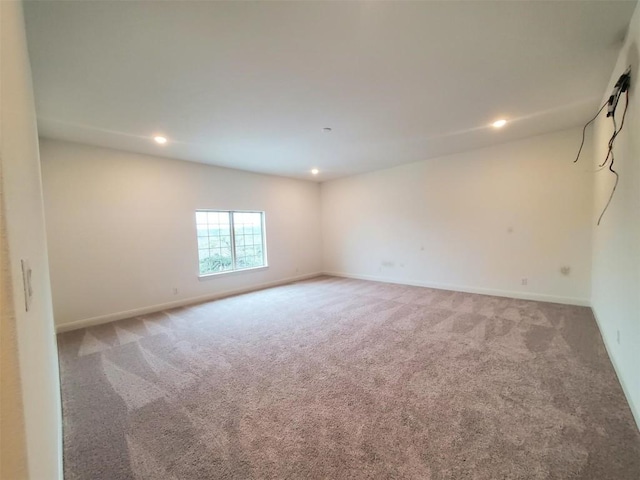 unfurnished room with recessed lighting, light colored carpet, and baseboards