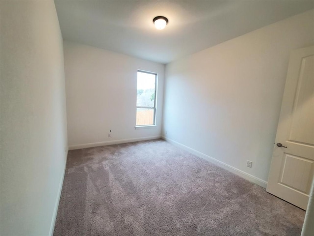 unfurnished room featuring carpet floors and baseboards