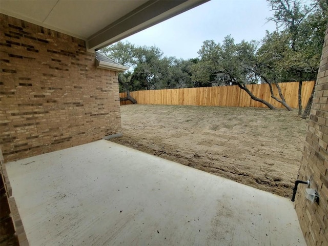 view of yard with fence and a patio