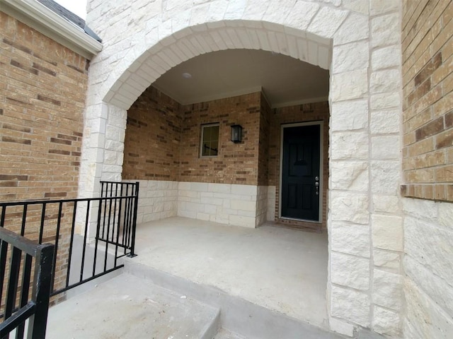 doorway to property with brick siding and stone siding