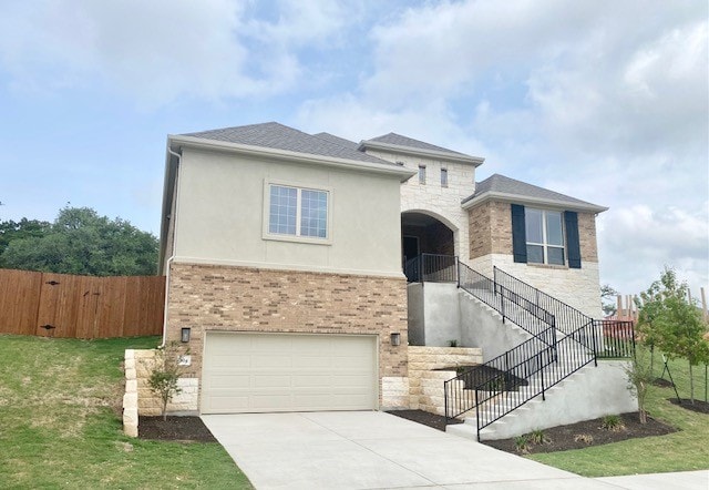 view of front of property featuring driveway, stone siding, an attached garage, and fence
