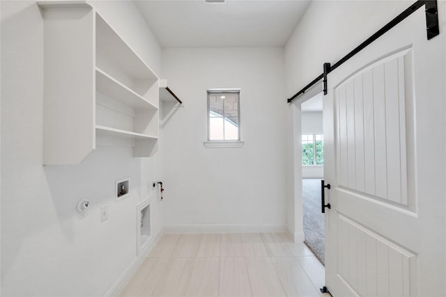 504 Frio Springs Trl, Georgetown, TX 78628 - washroom featuring hookup for a gas dryer, a barn door, washer hookup, hookup for an electric dryer, and light tile patterned floors