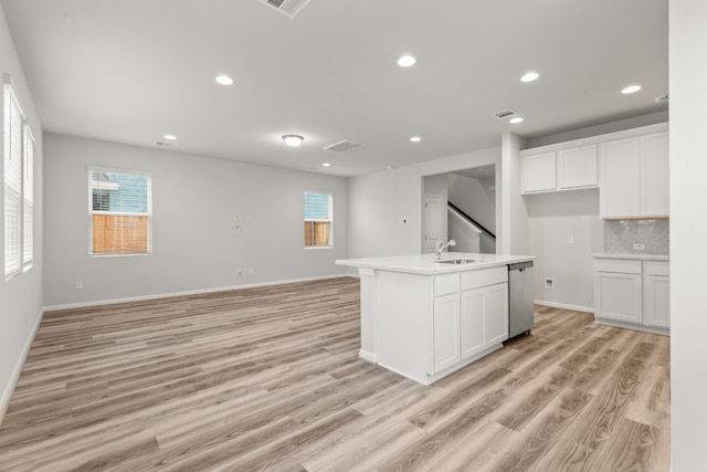 kitchen with white cabinetry, sink, and a center island with sink