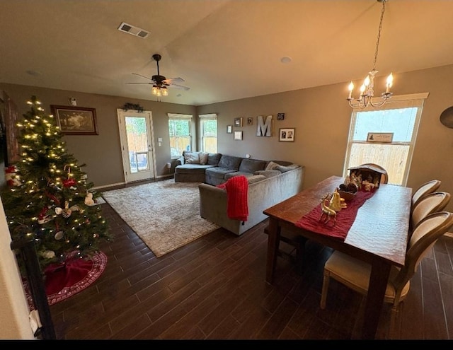 dining room with dark wood-type flooring and ceiling fan with notable chandelier