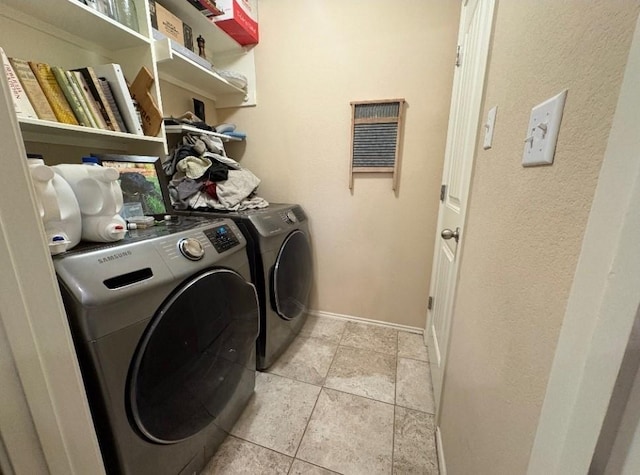 washroom with washing machine and clothes dryer and light tile patterned flooring