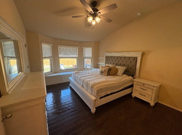 bedroom with ceiling fan, dark wood-type flooring, and vaulted ceiling