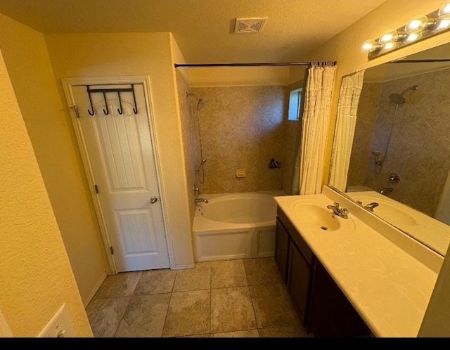 bathroom with shower / tub combo with curtain, vanity, and a textured ceiling