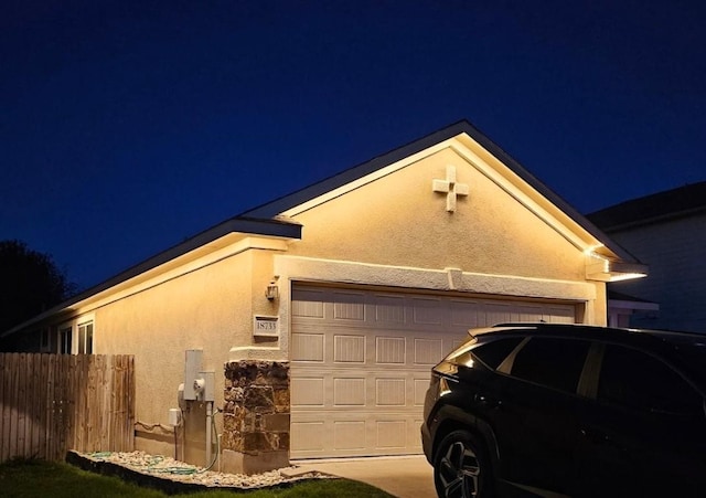 property exterior at night with a garage