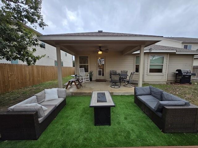 rear view of house with a patio area, ceiling fan, and an outdoor living space with a fire pit