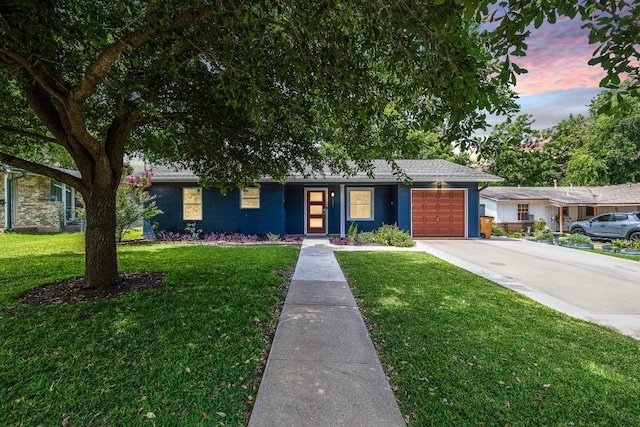 single story home with a lawn and a garage