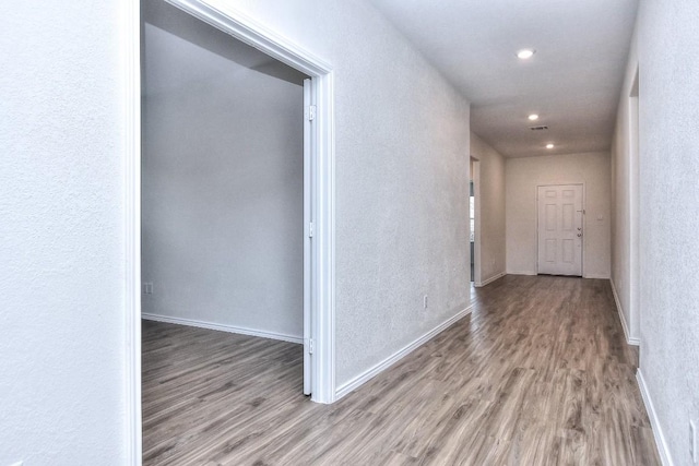 corridor with hardwood / wood-style flooring