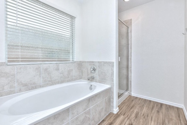 bathroom featuring shower with separate bathtub, plenty of natural light, and hardwood / wood-style floors