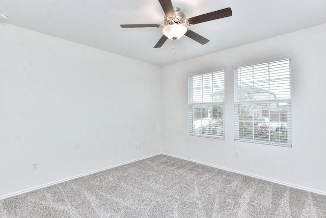 unfurnished room with ceiling fan and carpet