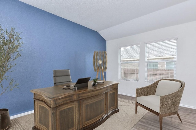 office area with light hardwood / wood-style flooring and lofted ceiling