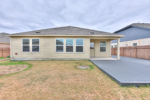 rear view of property featuring a patio, a deck, and a lawn