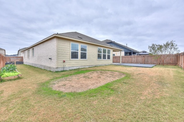 rear view of property featuring a lawn and a patio