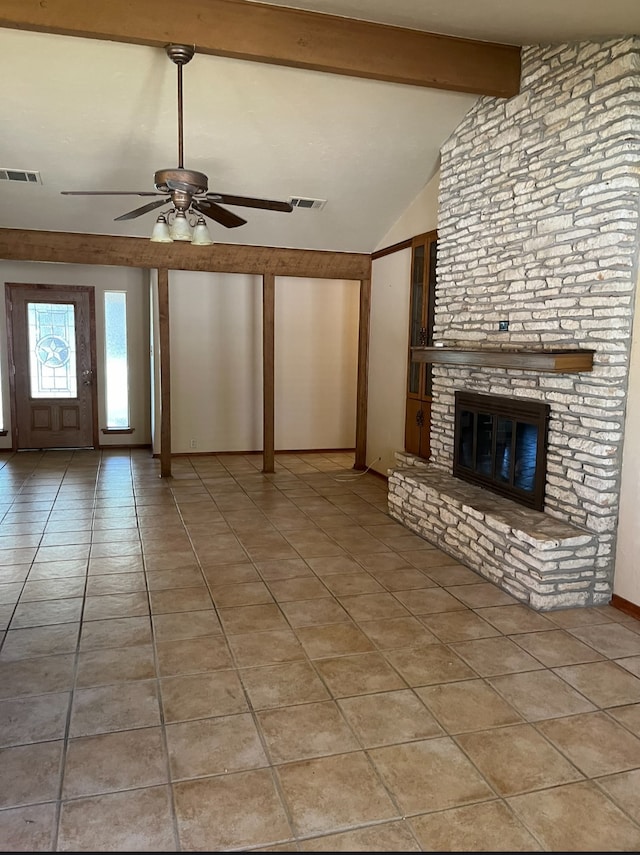 unfurnished living room featuring a fireplace, lofted ceiling with beams, ceiling fan, and light tile patterned flooring