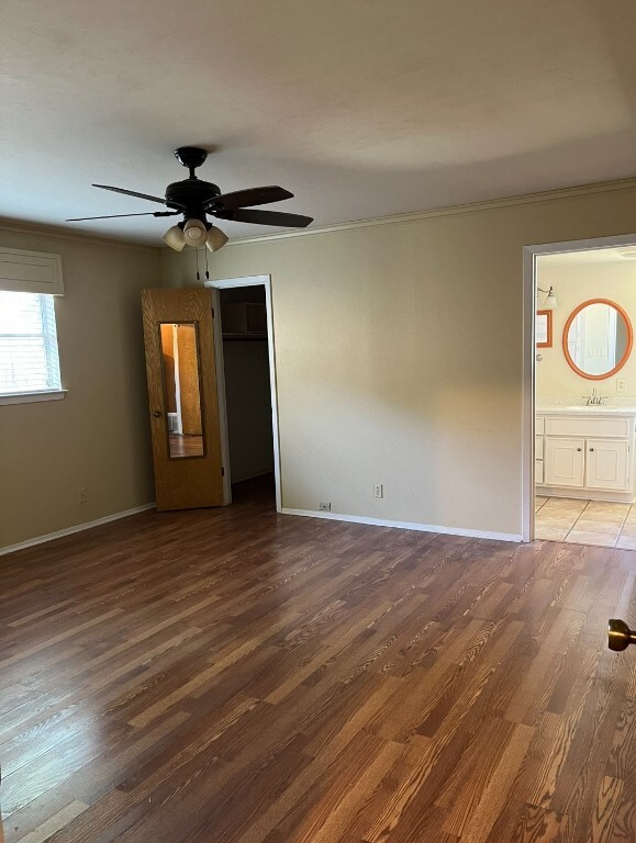 spare room with ceiling fan, ornamental molding, dark hardwood / wood-style floors, and sink