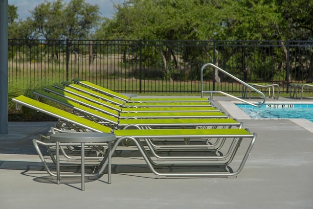 view of property's community with fence and a pool