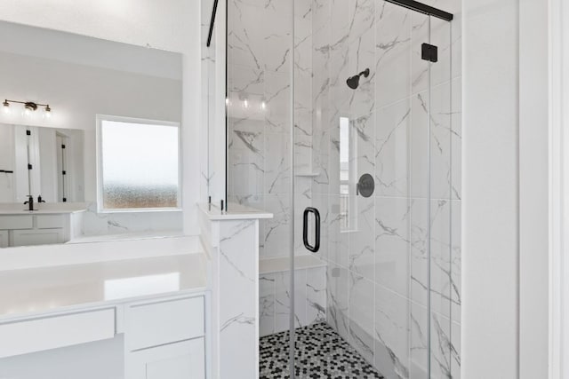 bathroom with vanity and a marble finish shower