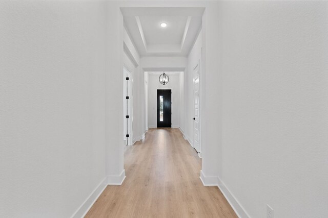 1701 Sauterne Dr, Leander, TX 78641 - hallway featuring an inviting chandelier, a raised ceiling, light wood-type flooring, and baseboards