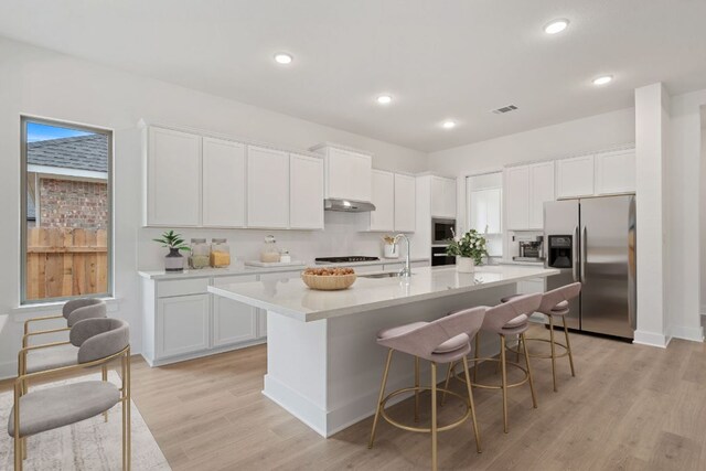 1701 Sauterne Dr, Leander, TX 78641 - kitchen featuring a sink, white cabinetry, appliances with stainless steel finishes, and under cabinet range hood