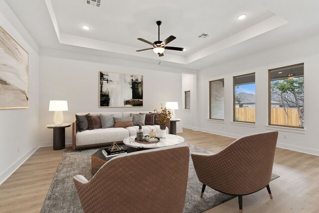 1701 Sauterne Dr, Leander, TX 78641 - living room featuring a tray ceiling, visible vents, light wood-style flooring, and a ceiling fan
