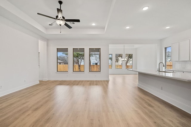 1701 Sauterne Dr, Leander, TX 78641 - unfurnished living room with a sink, a raised ceiling, and a wealth of natural light