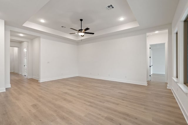 1701 Sauterne Dr, Leander, TX 78641 - empty room with visible vents, ceiling fan, light wood-style floors, and a tray ceiling