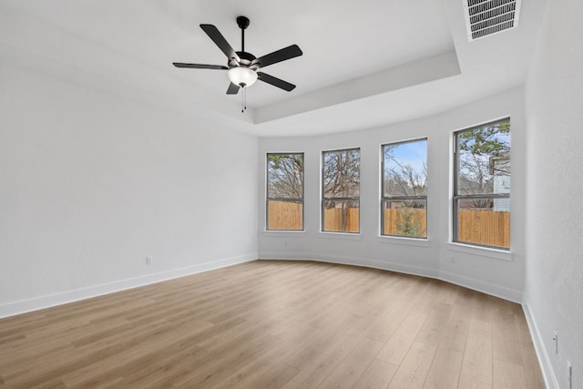 1701 Sauterne Dr, Leander, TX 78641 - spare room with a tray ceiling, baseboards, visible vents, and light wood-style flooring