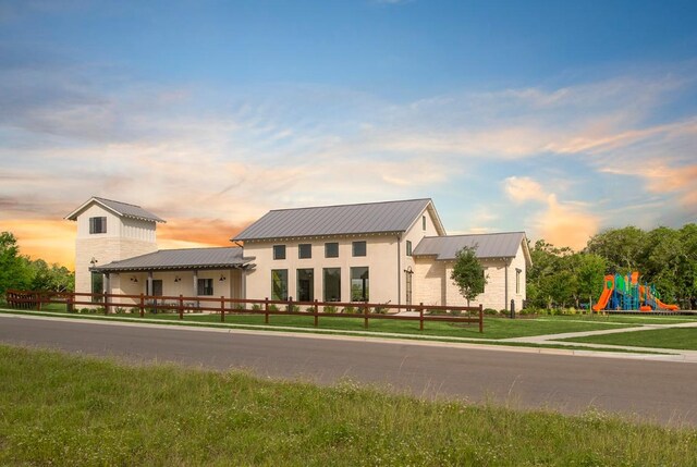 view of front facade with a lawn and a playground