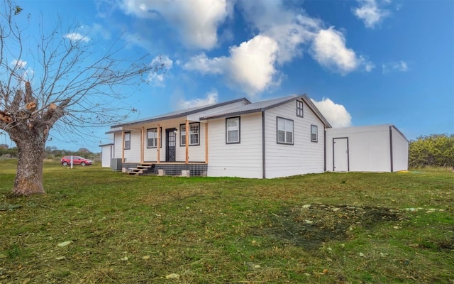 rear view of property featuring a porch, a yard, and central AC