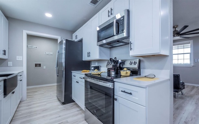 kitchen featuring ceiling fan, light hardwood / wood-style flooring, white cabinets, and appliances with stainless steel finishes