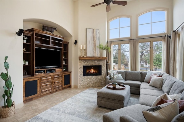 living room with ceiling fan and a high ceiling